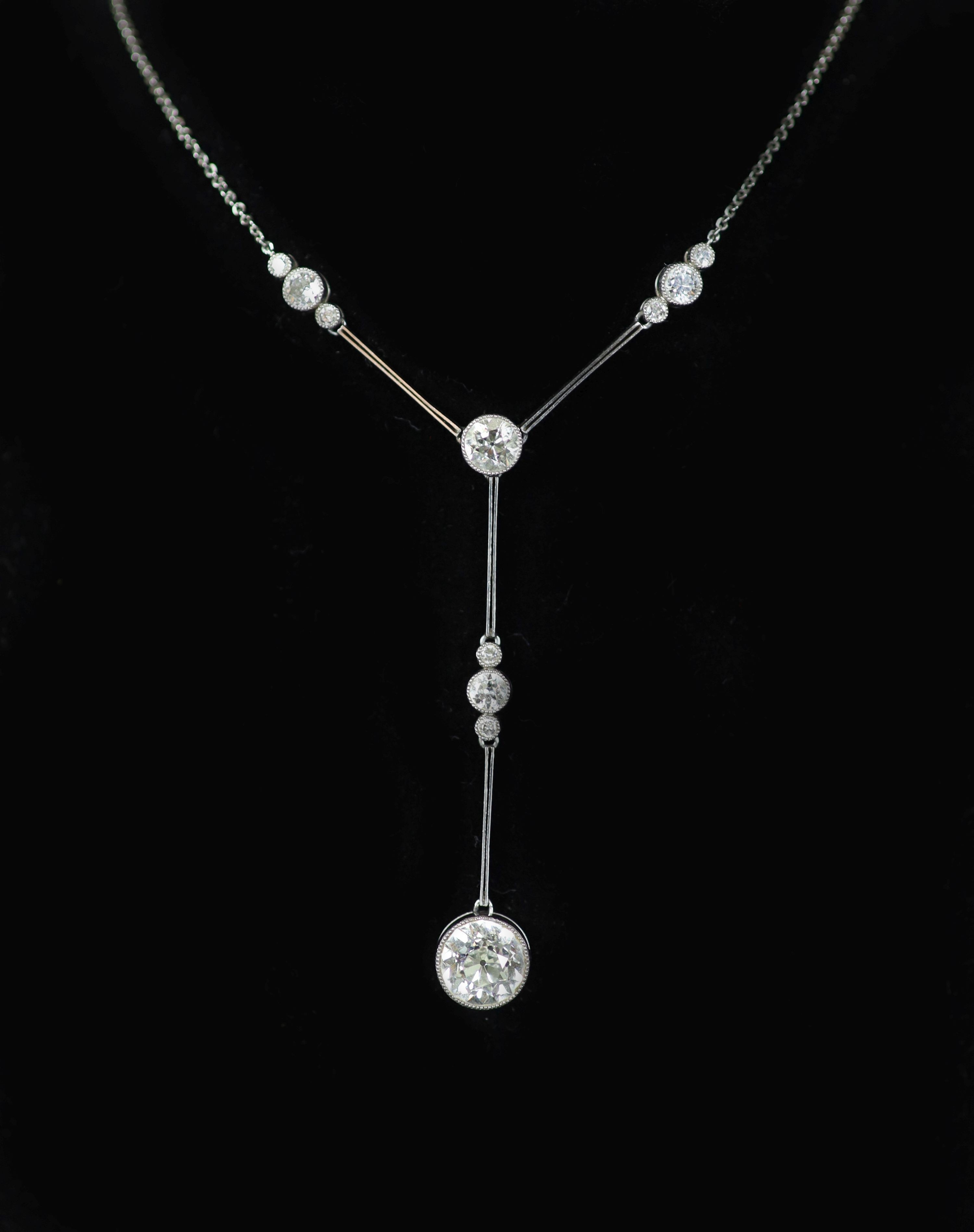 A 1920's platinum and eleven stone diamond set drop pendant necklace